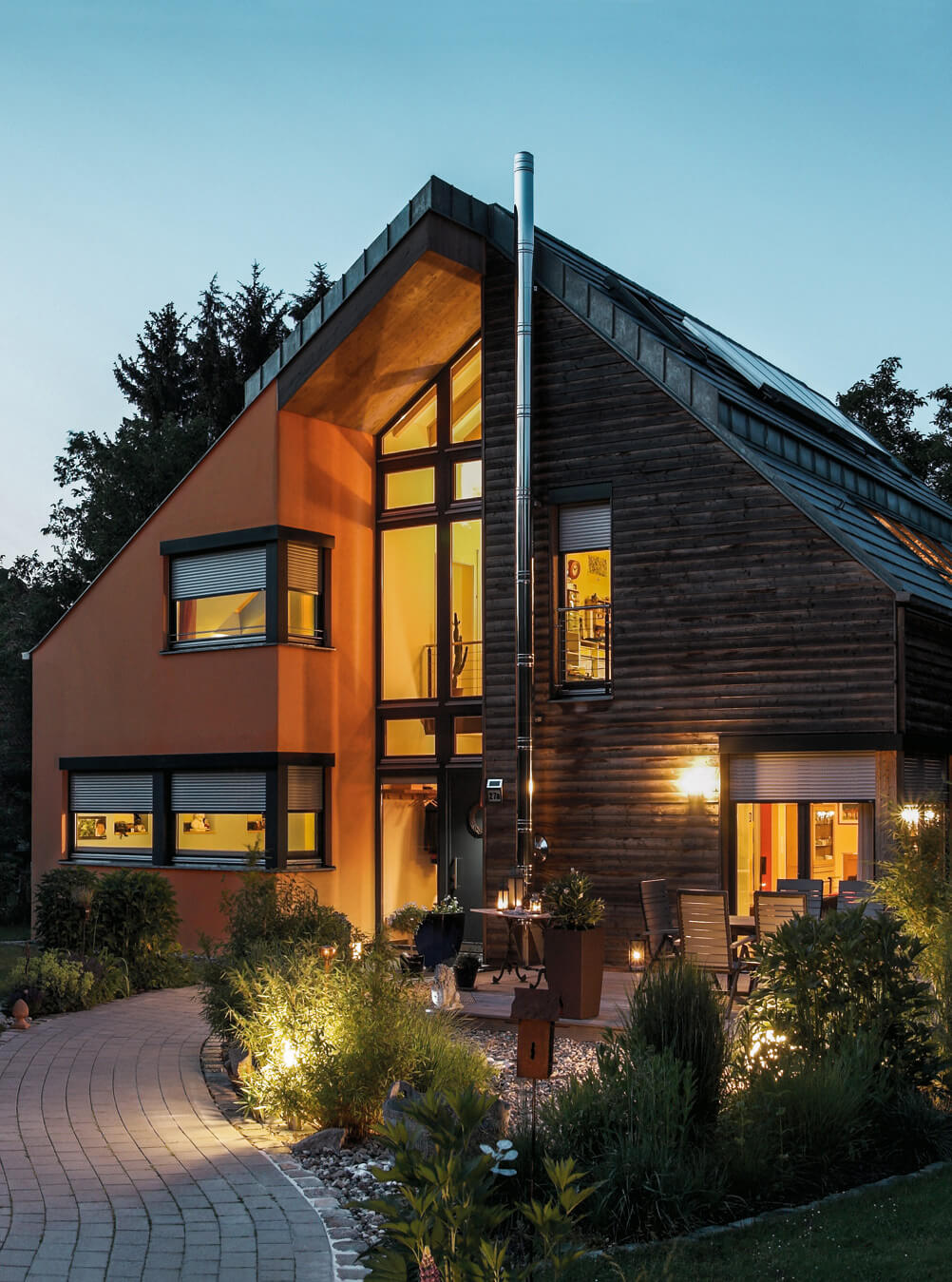 Haus am Abend mit Beleuchtung und halb runter gelassenen Rollladen